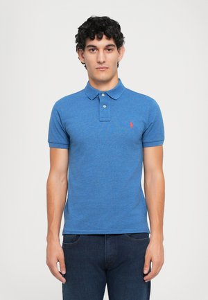 Polo shirt bleu à manches courtes, avec une patte de boutonnage à deux boutons et un petit logo rouge sur la poitrine gauche ; tissu texturé avec une coupe décontractée.
