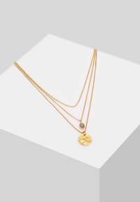 Dreireihige Goldkette mit einem gehämmerten runden Anhänger, einem ovalen Akzent und unterschiedlichen Kettenstilen mit glänzenden Oberflächen.