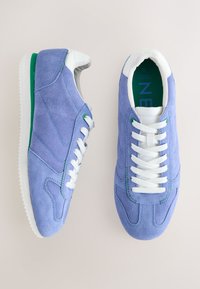 Sneakers in camoscio lavanda con accenti bianchi, suola verde e occhielli. Design con lacci, punta arrotondata e tomaia testurizzata.