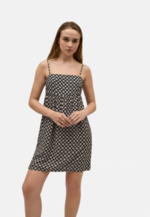 Vestido floral en blanco y negro con tirantes finos, escote cuadrado y diseño acampanado. Fabricado en tejido ligero, adecuado para el clima cálido.