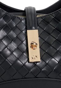 Black woven leather handbag featuring a gold hardware clasp and smooth leather strap, highlighting a textured pattern and polished finish.