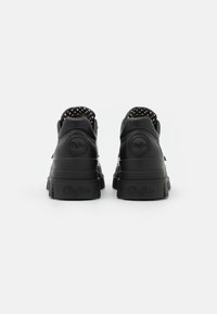 Sneaker platform nere in pelle con forma arrotondata, dettagli testo e interno a pois. Presentano un logo impresso sul tallone.