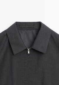 Dark gray collared jacket with a front silver zipper, showing the upper chest and collar area on a white background.