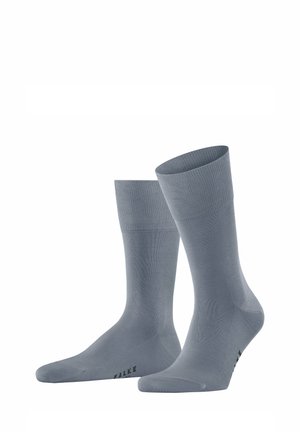 Calzini in cotone grigio a manica corta con orlo a coste, texture liscia e tallone rinforzato. Presenta il marchio nero "FALKE" sulla suola.