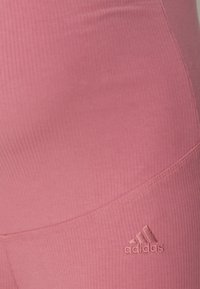 Rosa ribbade träningsleggings med en figurnära design, som har en liten pr präglad Adidas-logotyp, slät yta och kontrasterande sömdetaljer.