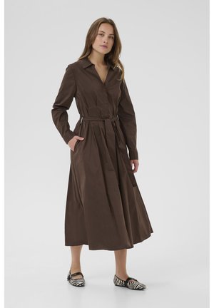 Brown long-sleeve shirt dress with a collar, belted waist, and side pockets. Styled with black and white striped ballet flats.