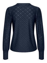 Blouse bleu marine à manches longues en tissu dentelle ajourée, épaules bouffantes et larges poignets boutonnés, vue de dos.