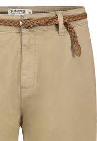Beige Baumwollmischhosen mit geflochtenem braunem Ledergürtel, glatter Oberfläche und einer Vordertasche. Das Etikett trägt die Aufschrift „SUBLEVEL“.