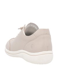 Baskets beiges clairs avec une tige en cuir texturé, des lacets élastiques et une semelle en caoutchouc blanc. Design à bout rond et détail de logo subtil sur le côté.