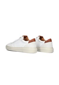 White leather sneakers with a smooth finish, brown suede heel accents, and cream rubber soles. Features lace-up design and perforated detailing.