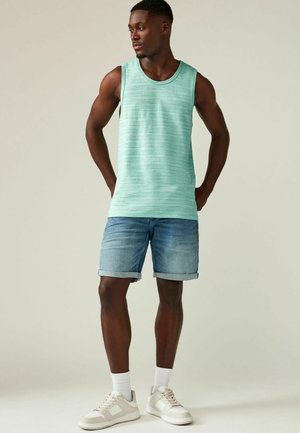 Müntzroheline triibuline tank top, denimpüksid koos volditud äärtega ja valged tennisetossud beežide detailidega. Lihtne, mugav suvine rõivastus.