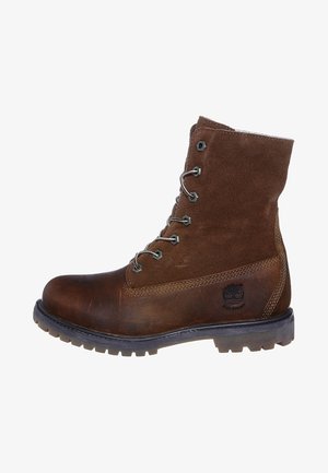 Brown leather and suede ankle boot with laces, rubber sole, and a logo on the side. Features a rugged design suitable for outdoor use.