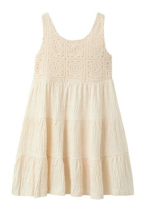 Robe sans manches crème avec corsage floral en crochet et jupe à volants texturée, conçue pour un port décontracté ou estival.