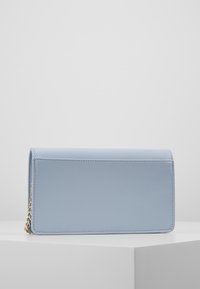Jasnoniebieski teksturowany portfel ze skóry o prostokątnym kształcie, wyposażony w złoty łańcuch do noszenia na ramieniu oraz starannie obszyte krawędzie.