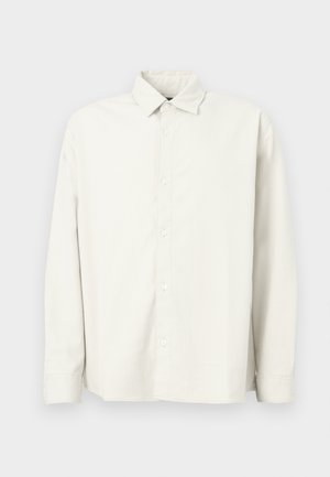 Lys beige langermet skjorte med knapper laget av teksturert stoff, med standard krage, vertikale striper og rett kant.