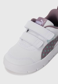 Vita sneakers med kardborreband, lila detaljer och en texturerad överdel med turkosa prickar på sidan.