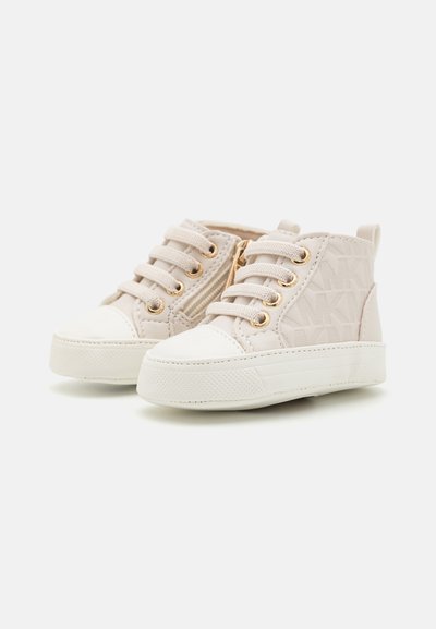 Helle beigen High-Top-Sneaker mit strukturiertem Obermaterial, goldenen Beschlägen, weißer Gummikappe und kontrastierender Sohle. Schnürdesign mit Logo-Akzenten.