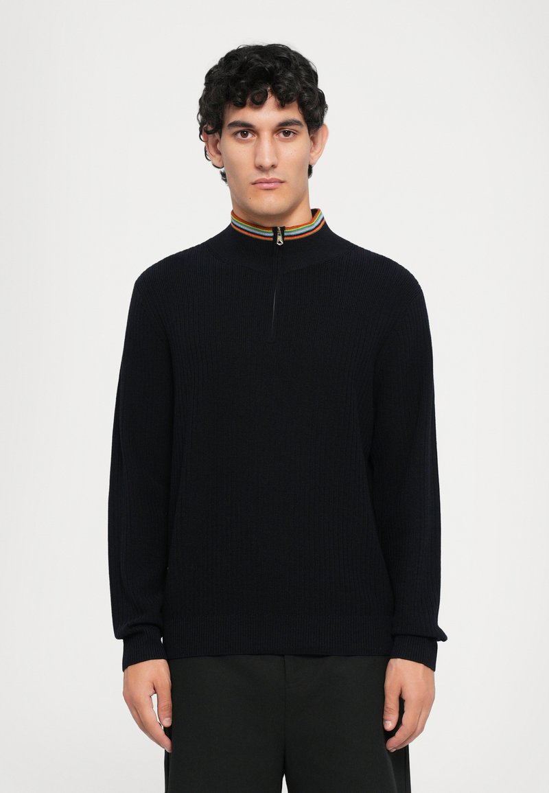 Maglione a coste blu navy con zip a un quarto e colletto a righe multicolori. Maniche lunghe, vestibilità rilassata e dettagli minimi.