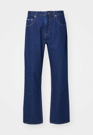 Granatowe dżinsy z prostymi nogawkami, pięcioma kieszeniami i subtelnymi detalami przeszycia. Posiadają zapięcie na guzik i zamek błyskawiczny.