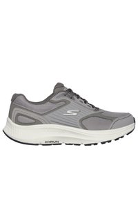 Zapatilla deportiva gris con parte superior de malla texturizada y acentos sintéticos. Diseño ligero con una suela blanca acolchada y una plantilla negra.