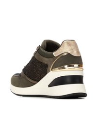Zapatillas verde oliva con parte superior texturizada oscura, detalles en dorado metálico y suela de cuña blanca con base negra. Materiales suaves y con patrones.