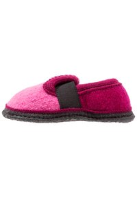 Roze vilten slipper met een donkergrijze zool, afgeronde vorm en een zwarte verstelbare band over de bovenkant voor een veilige pasvorm.