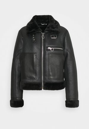 Black textured leather jacket with zip front, two large front pockets, fur-lined collar and cuffs, and silver buckle and zipper details.