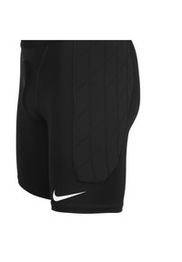 Schwarze Sportshorts aus dehnbarem Material, mit gepolsterten Seiten und einem weißen Nike-Logo auf der unteren linken Seite.