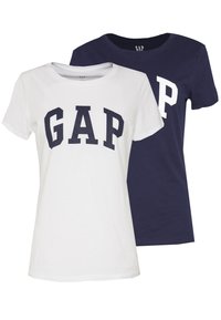 To t-skjorter med merket "GAP." Den ene er hvit med marineblå skrift, og den andre er marineblå med hvit skrift. Begge har rund hals-design.