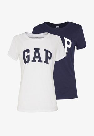 Dos camisetas con la marca "GAP". Una es blanca con letras en azul marino, y la otra es azul marino con letras en blanco. Ambas tienen un diseño de cuello redondo.
