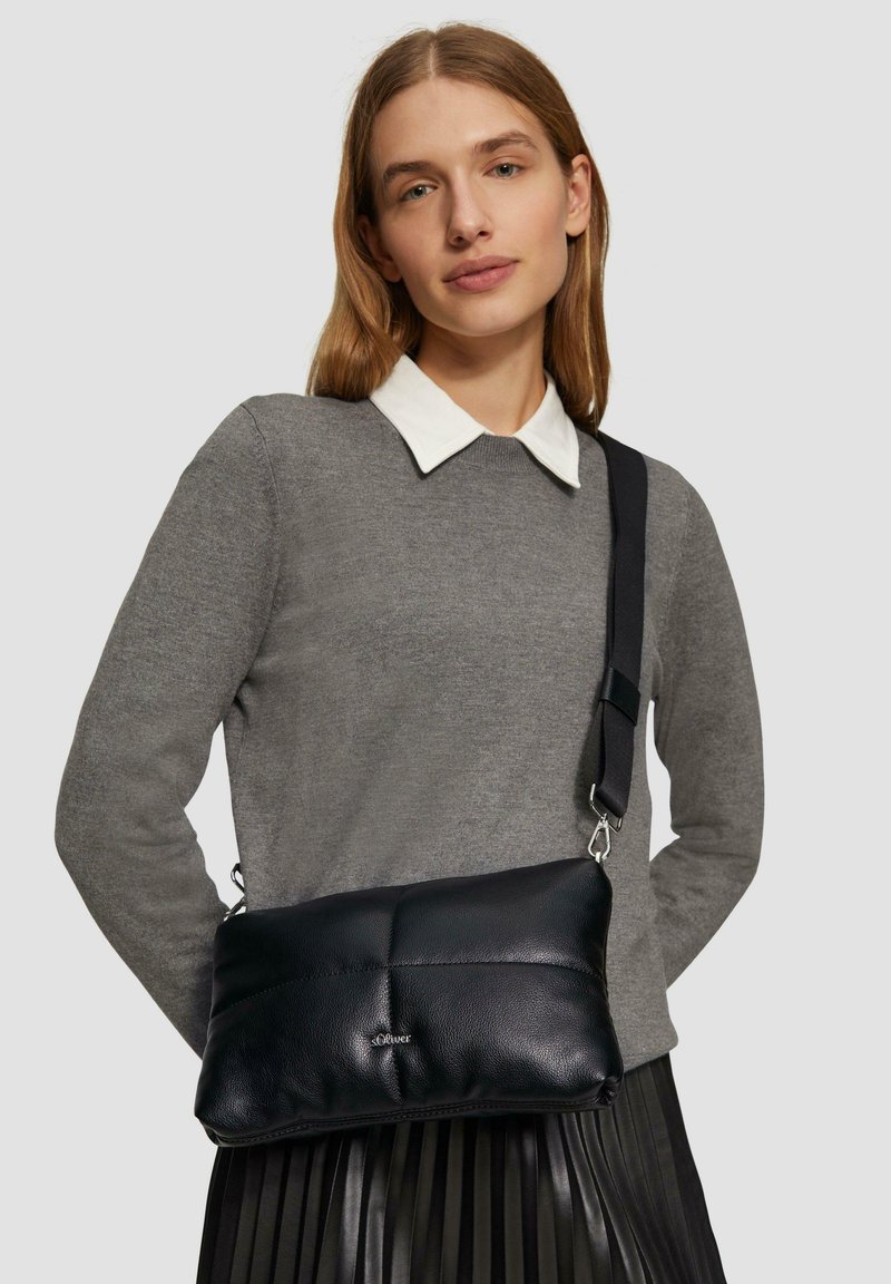 Schwarze Ledertasche mit einem gesteppten Design und silberner Hardware. Verfügt über einen abnehmbaren Trageriemen und eine glatte Textur.