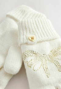 White knitted gloves featuring a ribbed cuff, a decorative golden bow made of rhinestones, and a gold heart-shaped button detail.