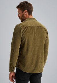 Khaki corduroy overhemd met lange mouwen, subtiele ribbelstructuur, knoopmanchetten en een afgeronde zoom, gezien van de achterkant.