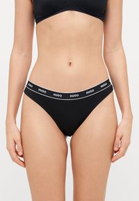 Czarne majtki bikini z białym logo "HUGO" na elastycznym pasie. Wykonane z miękkiego, elastycznego materiału. Minimalistyczny design i bezszwowe krawędzie.