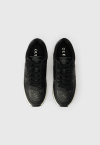 Melni sporta apavi ar ādas un auduma augšdaļu, ar teksturētu rakstu, apaļām auklām un baltu vidussole. Logo redzams uz mēles.