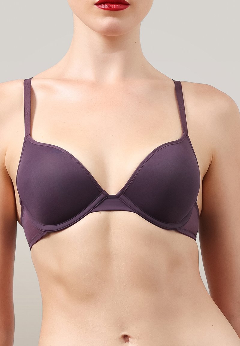 Lila BH med slätt tyg, bygel och justerbara band; har en djup skärning och sömlösa kupor för en slank look.