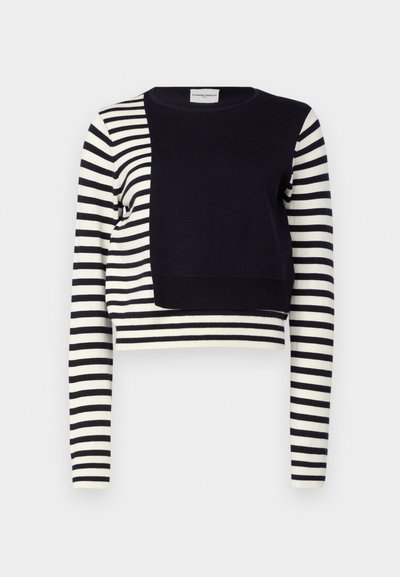 Top court en bleu marine et blanc à rayures, avec des manches longues et un panneau solide bleu foncé à l'avant. Fabriqué à partir d'un matériau en tricot doux.