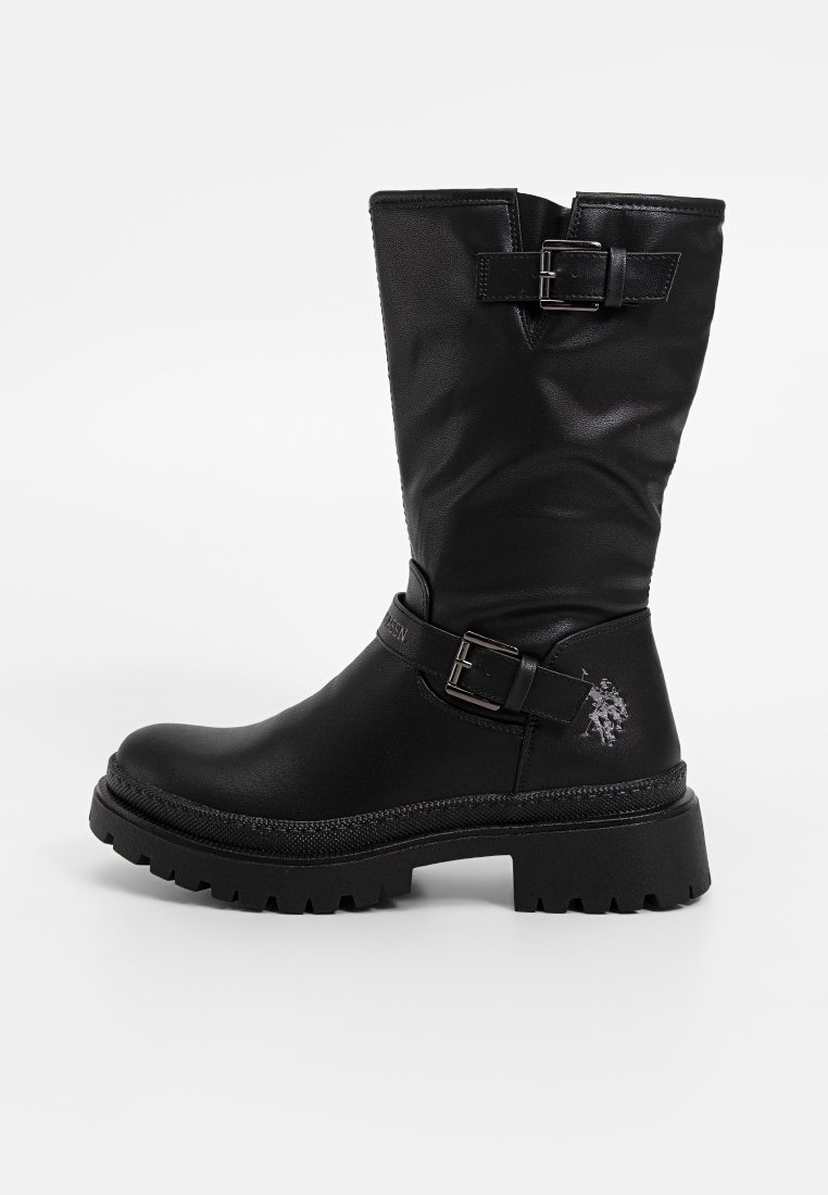 Stivale nero al ginocchio realizzato in materiale sintetico liscio, con dettaglio della cintura in fibbia e suola in gomma testurizzata con battistrada profondo.