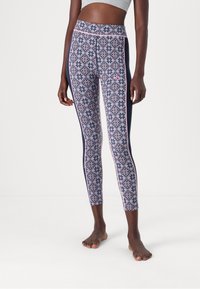Leggings i marinblått och mönstrad tyg med rosa geometriska mönster. Hög midja med kontrasterande sidopaneler. Mjukt, stretchy material.