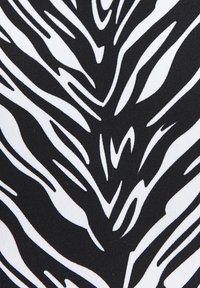 Zwarte stof met een gedurfde, abstracte witte patroon met golvende lijnen, wat een textuur en visuele diepte creëert.