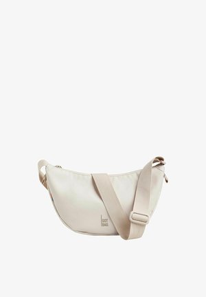 Beige, halbmondförmige Umhängetasche mit verstellbarem Riemen und "GOT BAG."-Logo auf der Vorderseite vor weißem Hintergrund.