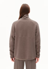 Bruine fleece jas met een hoge kraag, een relaxte pasvorm en een gestructureerd oppervlak. Beschikt over een rechte zoom en minimale stikdetails.