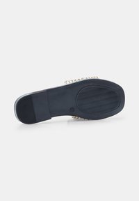 Melna zole ar teksturētu saķeri un elegantu dizainu. Augšdaļa ar zelta ķēdes akcentiem. Uzsvars uz minimālisma stilu un izturību.