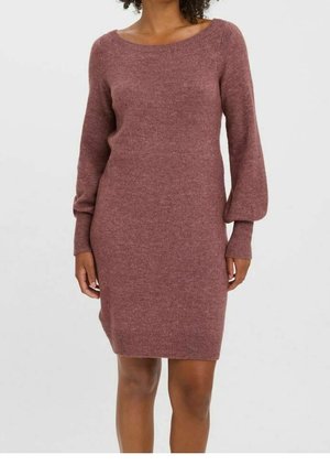 Femme portant une robe pull mauve en maille à manches longues avec poignets et ourlet côtelés, debout devant un fond clair uni.