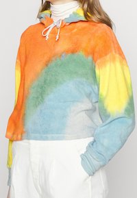 Felpa con cappuccio tie-dye in tonalità di arancione, giallo, verde e blu; texture morbida; design corto con dettagli a coulisse sul collo.