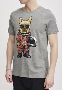 Grå bomulls-T-skjorte med en tegneserie fransk bulldog i en oransje astronautdrakt med svarte solbriller, som holder en romhjelm.