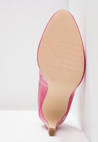 Rosa högklackad sko med en slät lackläderfinish, spetsig tå och beige sula märkt med "Tamaris" och storlek 37.