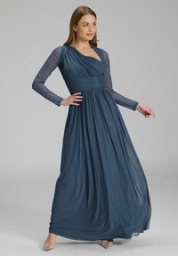 Pitkähihaista, syvänsinistä maksimekkoa, joka on valmistettu virtaavasta kankaasta. Mekossa on laskostettu yläosa, kerätty vyötärö ja läpinäkyvät hihojen, joissa on hieno kiilto.