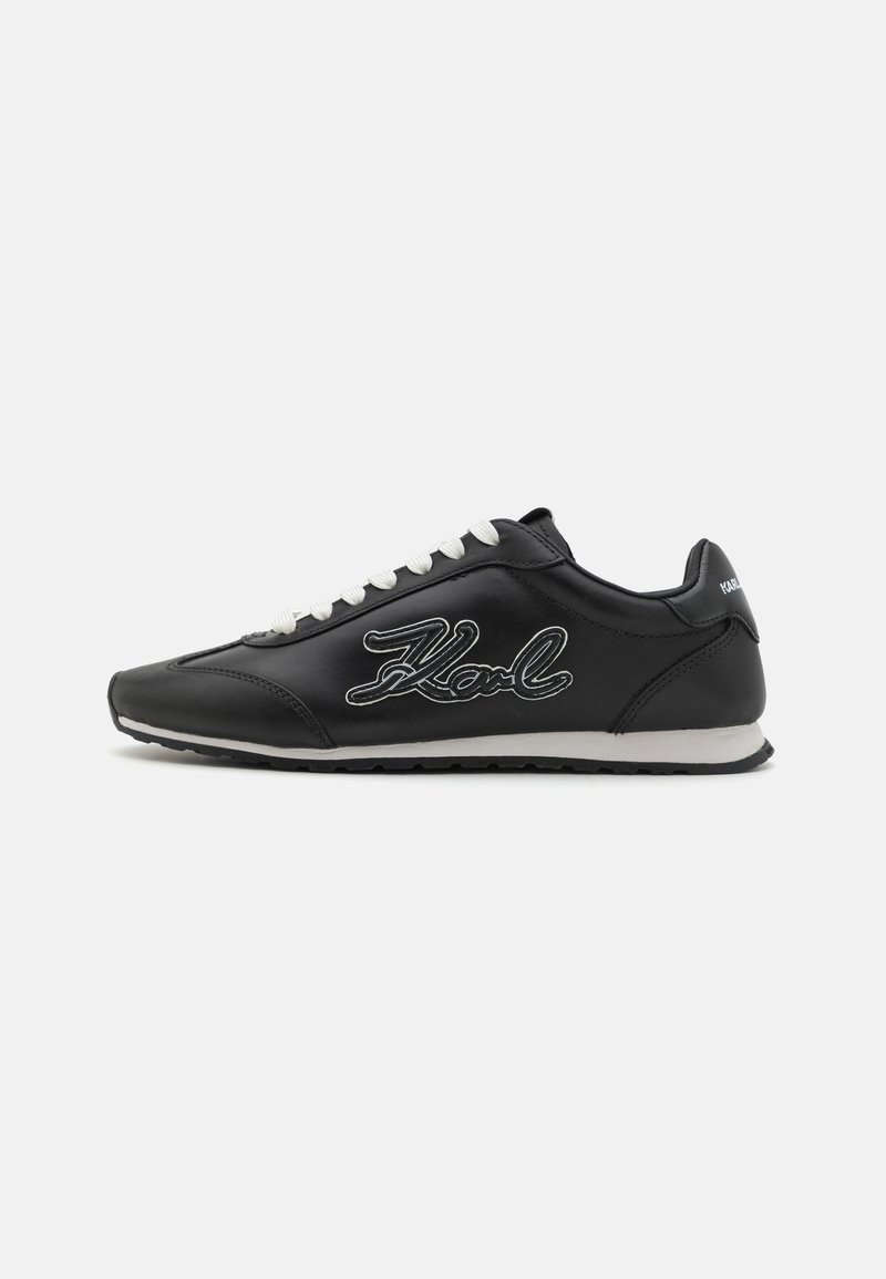 Black leather sneaker with white laces and embroidered 'Karl' logo on the side. Features a rounded toe and textured rubber sole.
