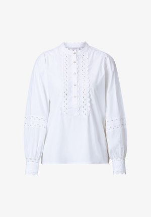 Witte lange mouwen blouse met golvende kraag en knoopsluiting. Heeft ingewikkelde uitsnijdingen op de mouwen en aan de voorkant, en knoopsluitingen.